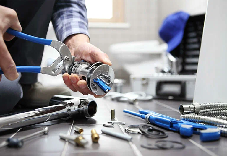 Technician repairing a plumbing fixture with professional tools in Clearwater