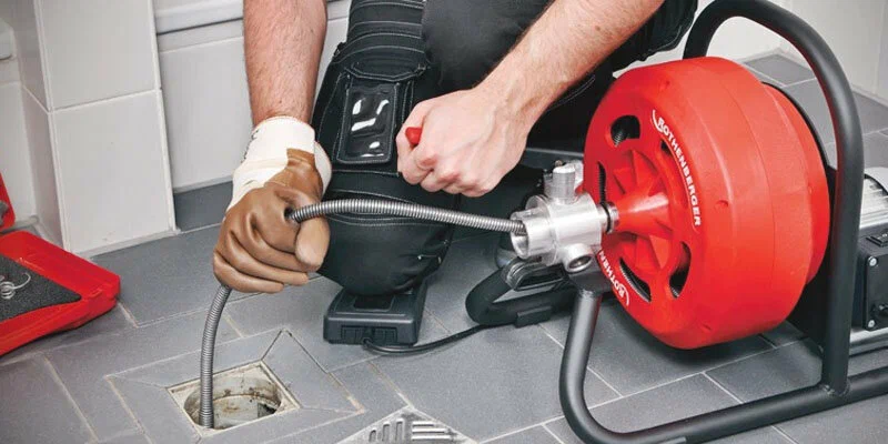 Plumber using a drain-cleaning machine in Clearwater